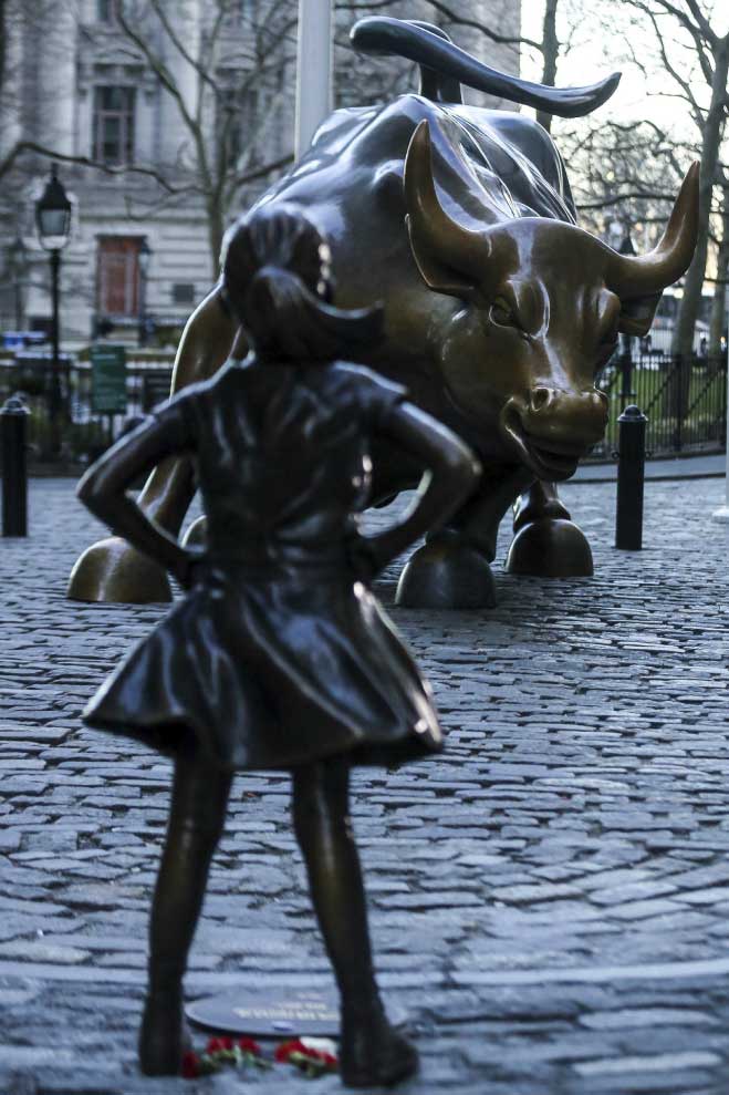 girl standing fearless in front of charging bull