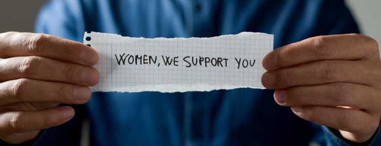 man holding paper saying women we support you