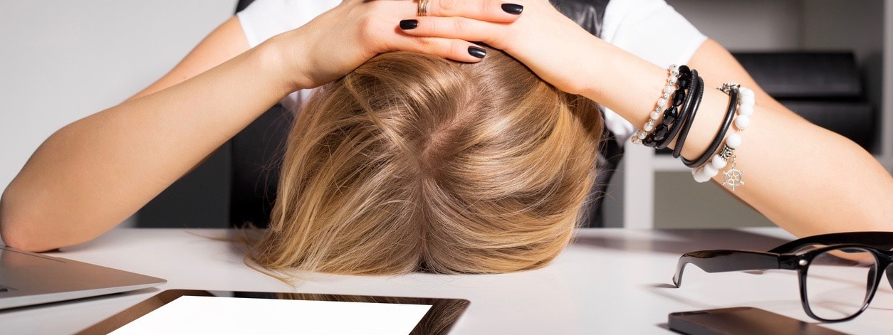 Tired business woman resting her head on desk