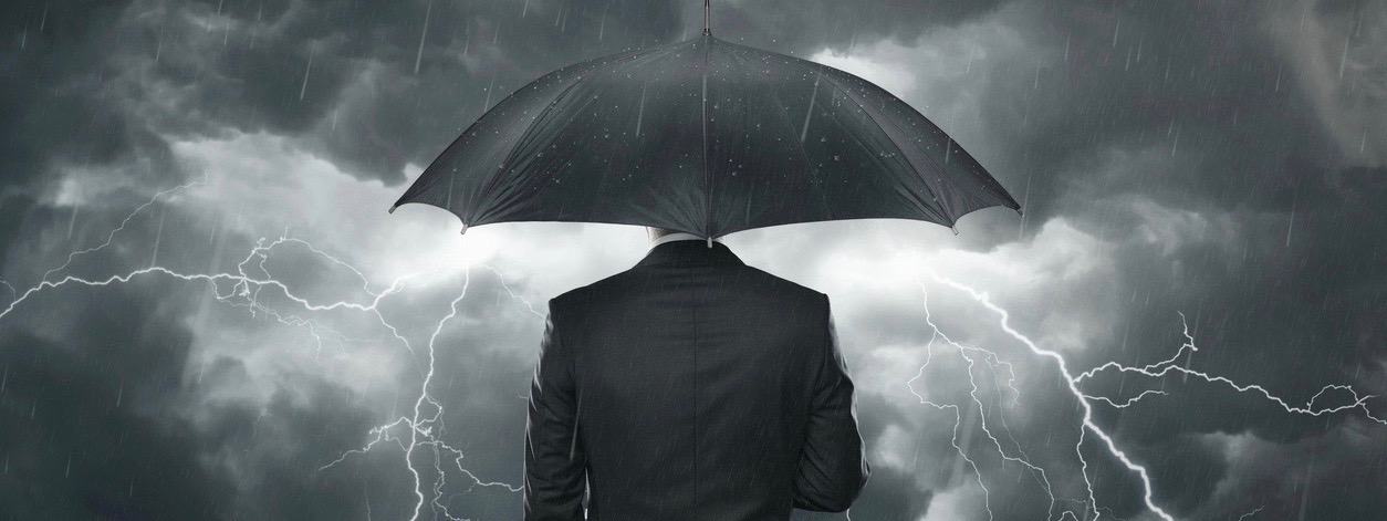 Businessman with umbrella standing in the rain
