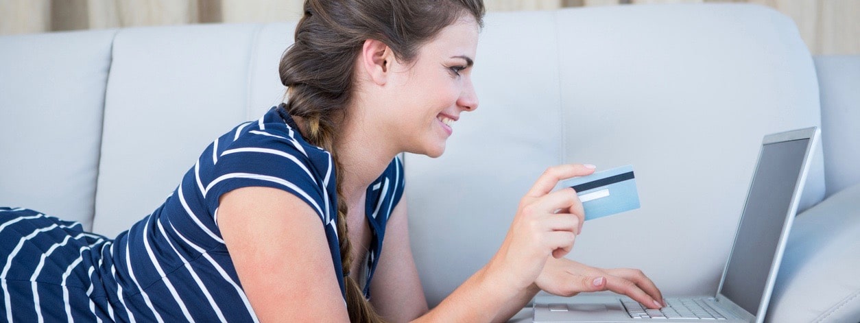woman lying on couch doing online shopping