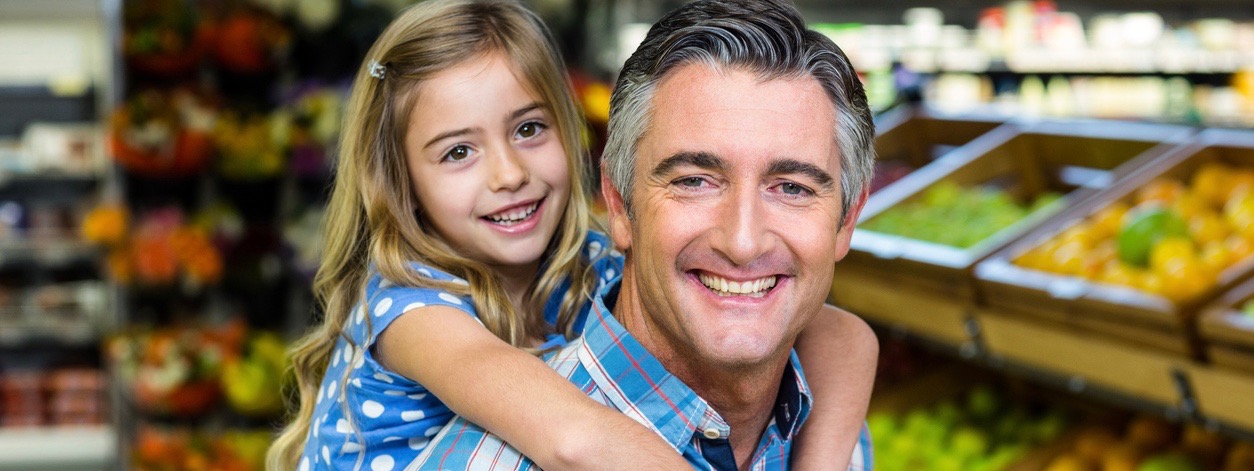 Daughter staying on her fathers back in supermarket