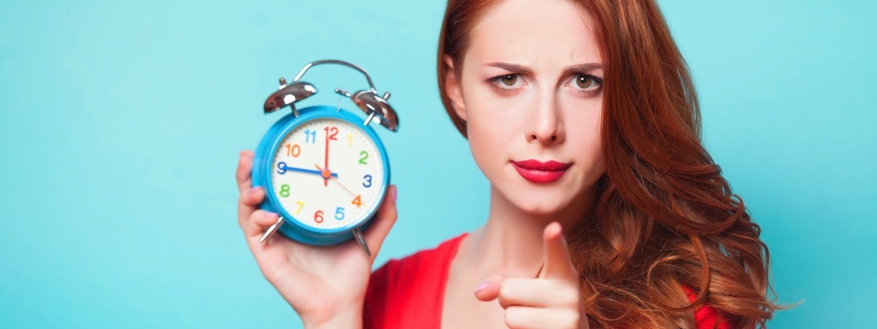 Girl with alarm clock on blue background.