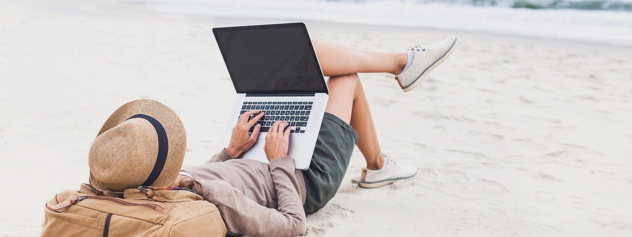 Resting woman using laptop on a beach