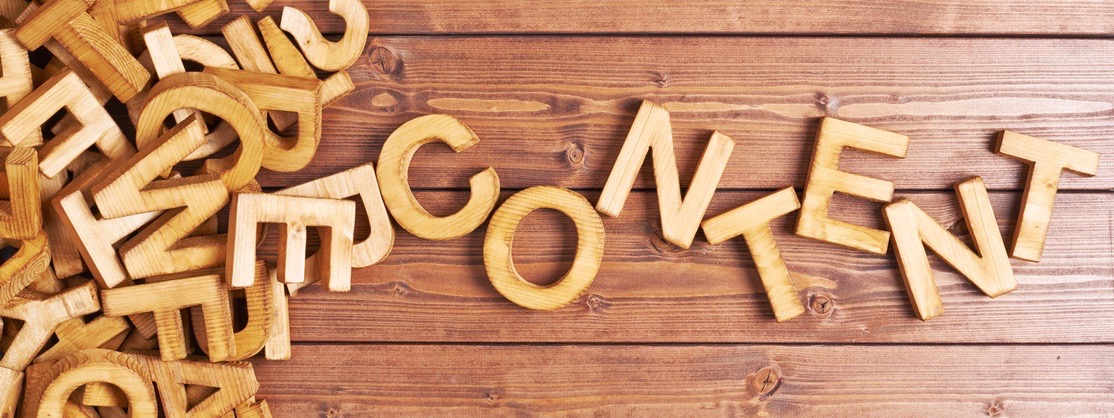 Word content made with block wooden letters next to a pile of other letters over the wooden board surface composition
