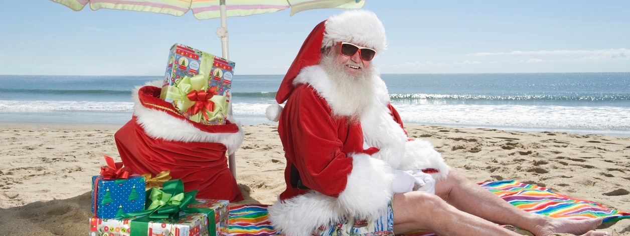 Santa relaxing on beach with gifts and presents