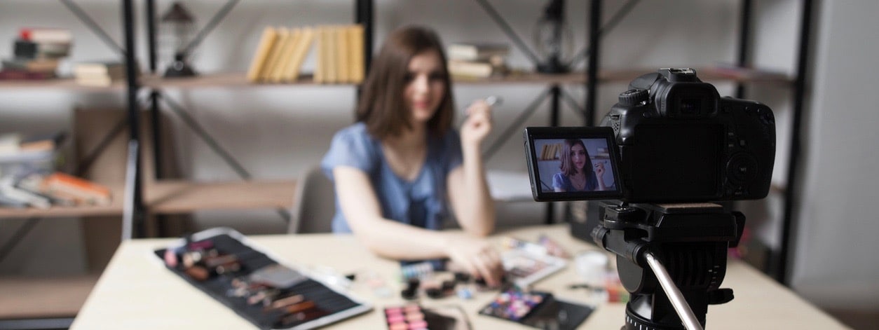 Female vlogger recording video at home.