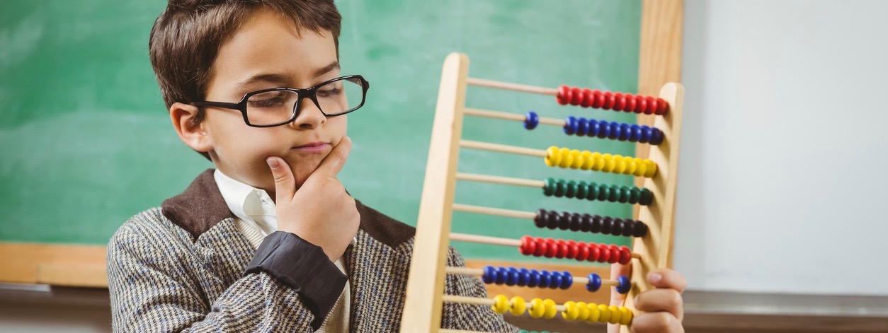 Pupil dressed up as teacher holding abacus in a classroom
