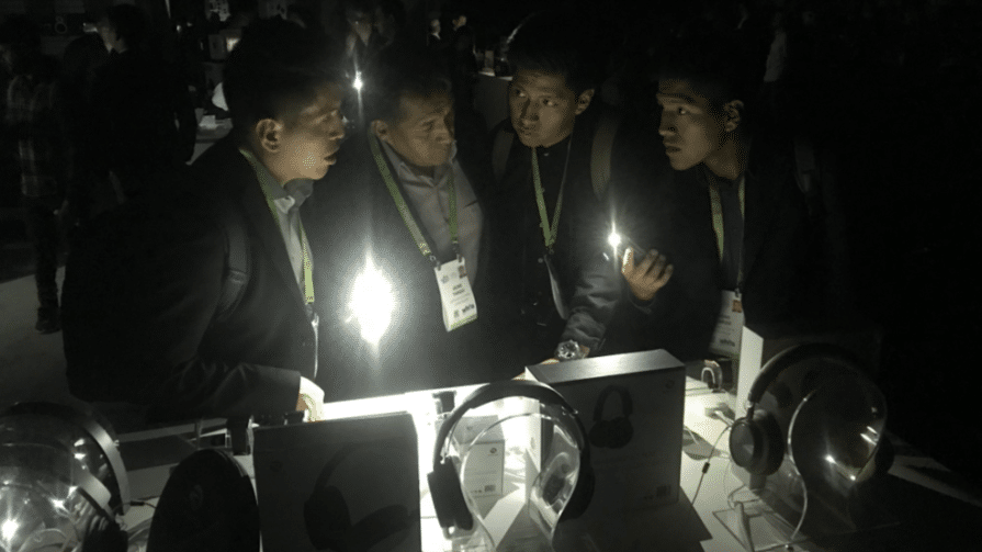 Four men standing in the dark, looking at new gadgets. The photo demonstrates newsjacking in action.
