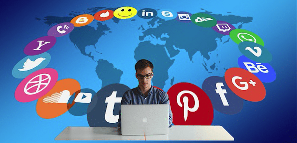 A man looking at his laptop, the icons representing social networks and other platforms surrounding him