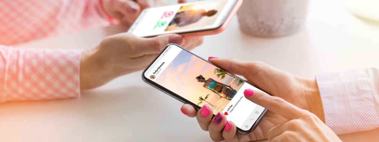 Two women using their mobile phones together