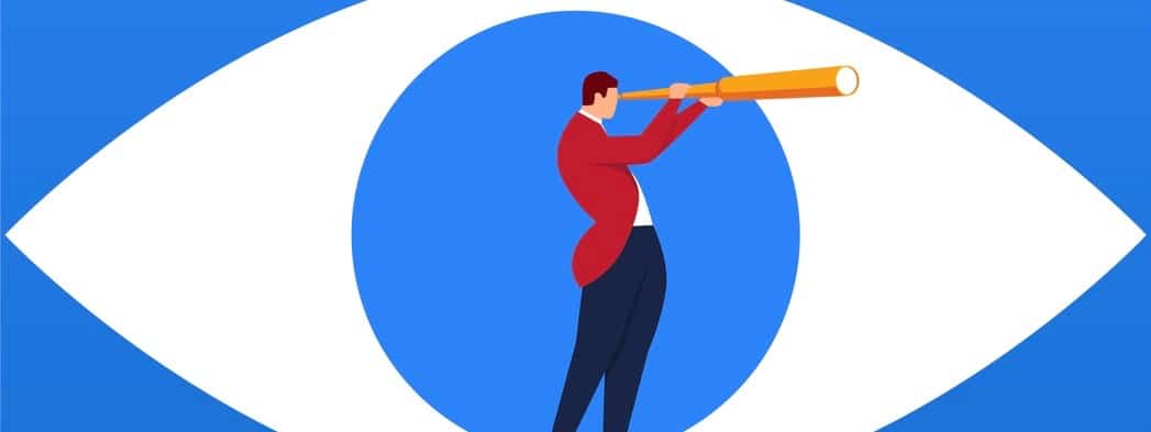 Businessman holding a telescope standing inside the eyes looking into the distance