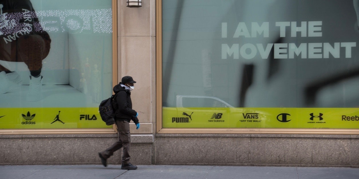 Person wearing Face Mask in Front of Billboard