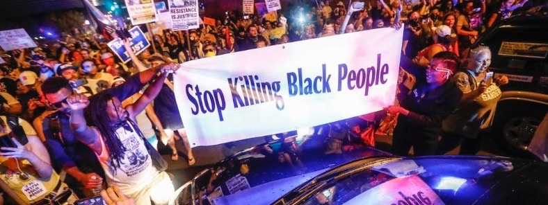 Protesters holding banner that says "Stop killing black people"