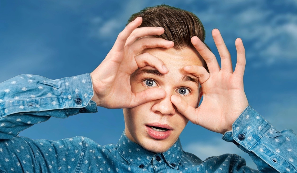 Portrait young guy dressed blue shirt man open his eyes wide with hands fingers and mouth. Man on blue sky background. (Portrait young guy dressed blue shirt man open his eyes wide with hands fingers and mouth. Man on blue sky background.