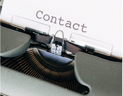 A typewriter with a “Contact” word written on the page.