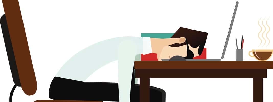 Tired office man sleeping at working desk
