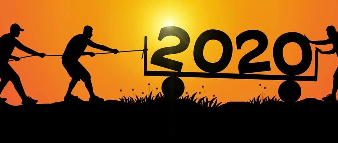 Silhouette of men helping push and pull 2020 on golden sunrise background.