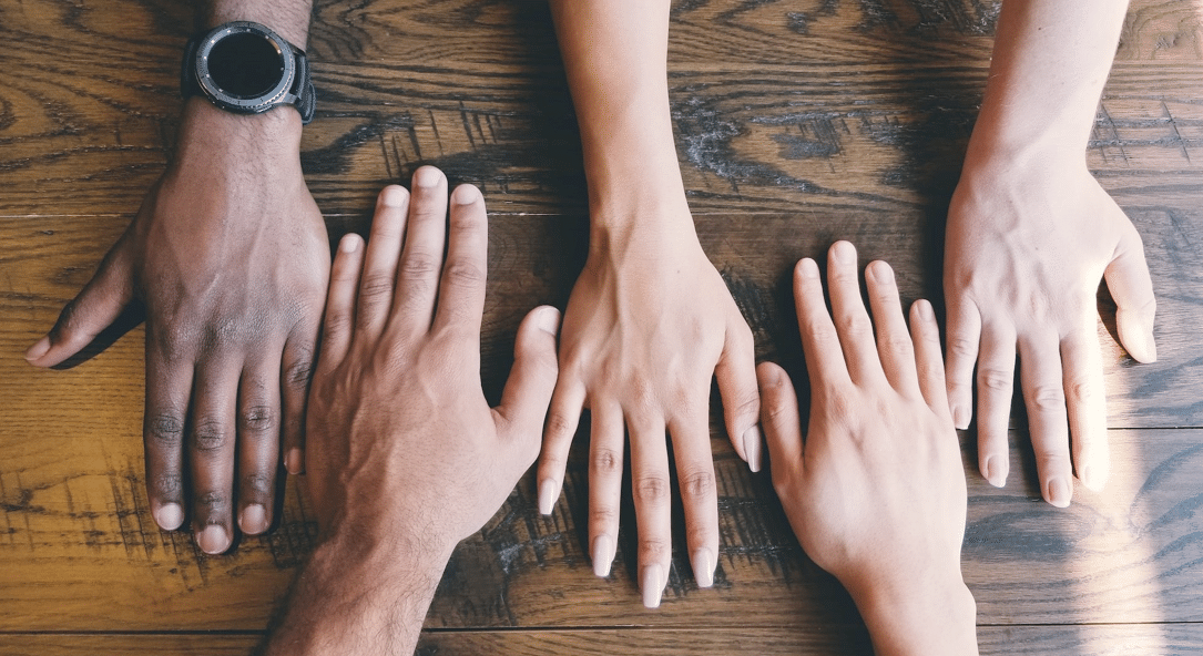 A diverse collection of hands placed next to one another.