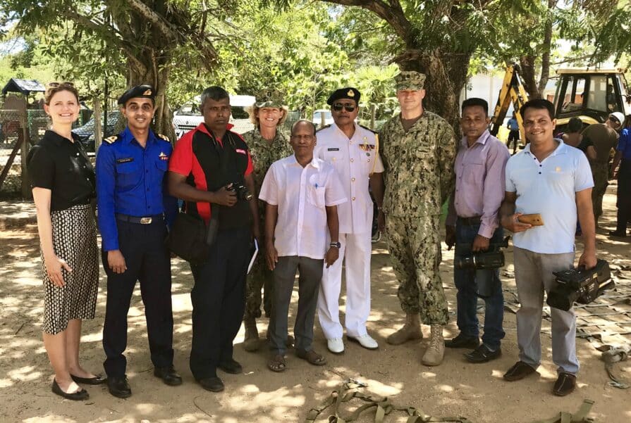 Amy with members of Sri Lankan media standing beneath trees