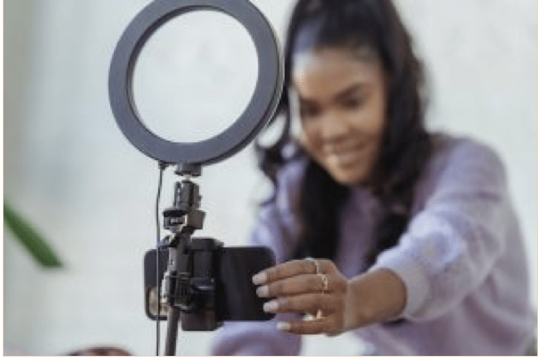 Influencer wearing a purple setting up her camera to record herself