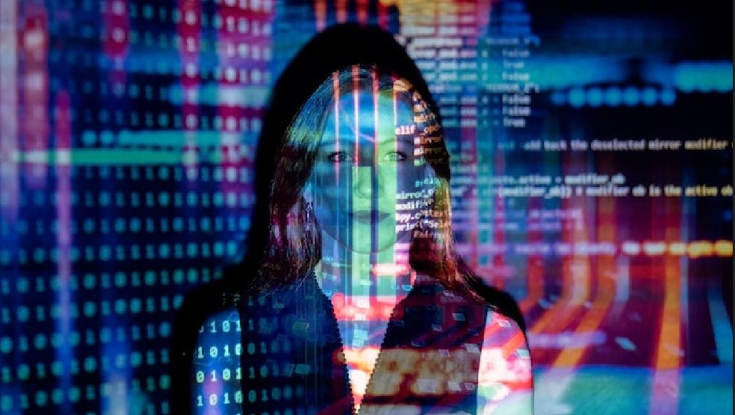 Code being projected on a wall while a woman is standing in front of it