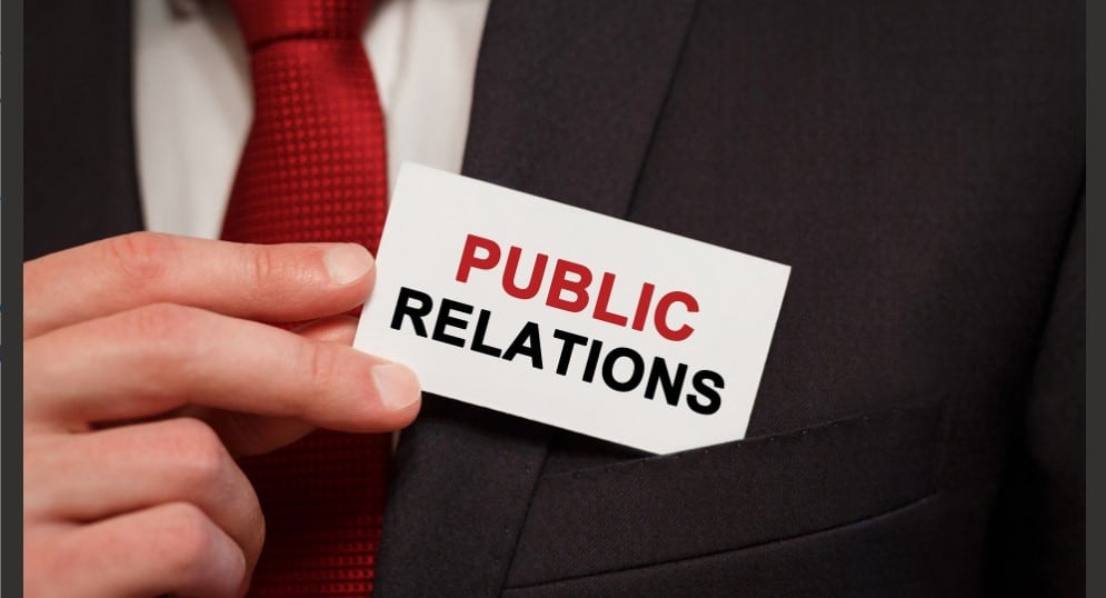 A businessman holding a card that say public relations 