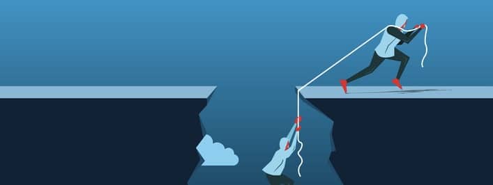 Businessman Pulling Partner Up The Deep