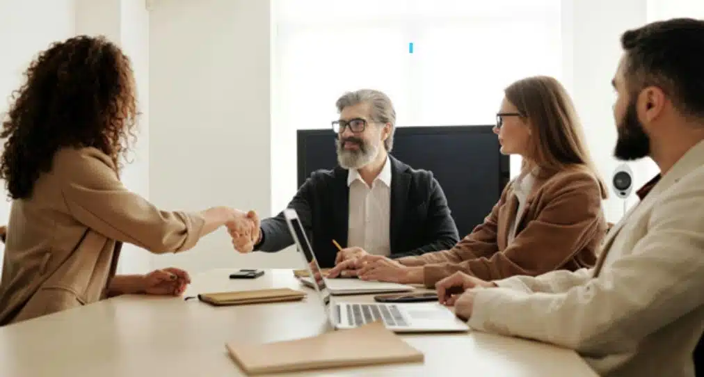 A man in a suit shaking hands with a woman 