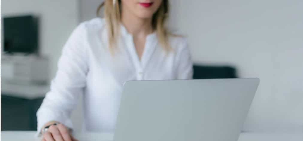A woman using her silver laptop in the office