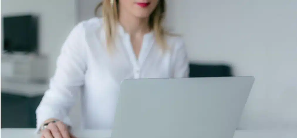 A woman using her silver laptop in the office 