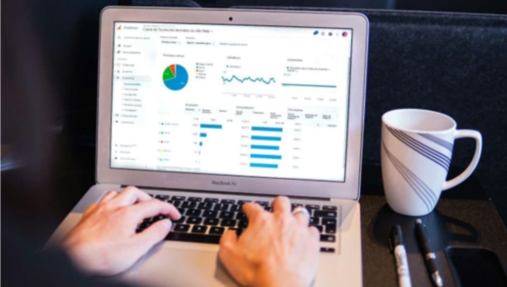 Person looking at an analytics report on a MacBook. 