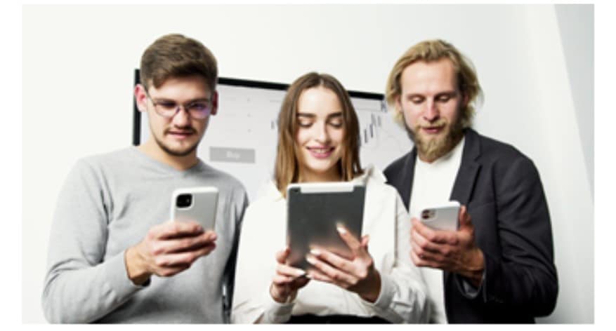 Three people looking at their mobile devices. 